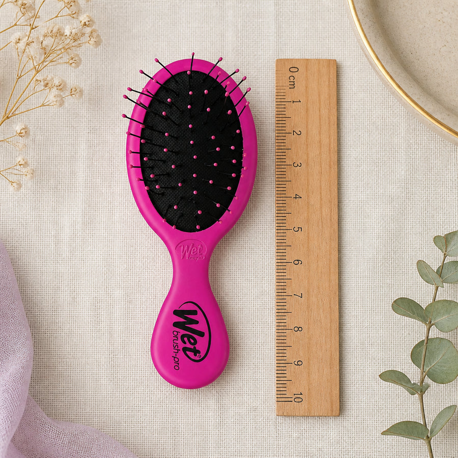 Wet Brush Baby Violet — flatlay présentation éditoriale (brosse centrée avec accessoires bébé)