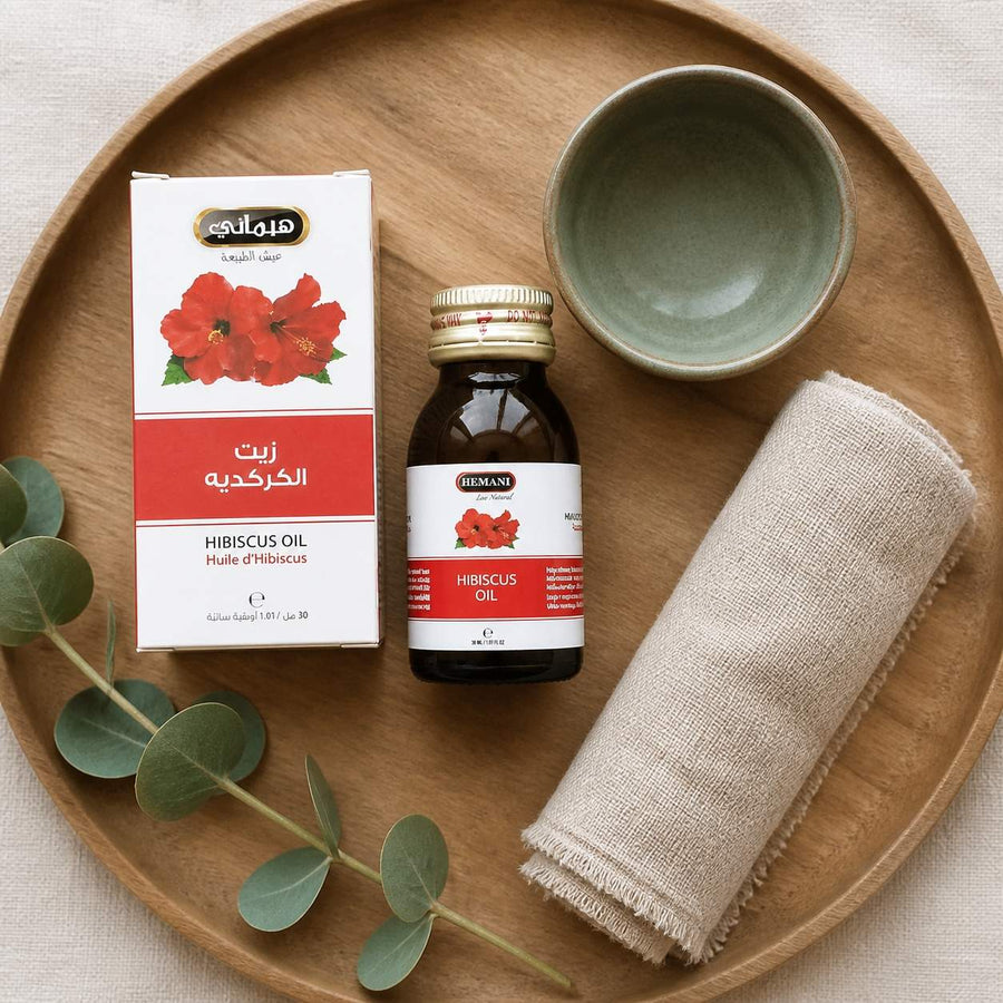 2 Huile d'Hibiscus 30mL 100% Naturelle Hemani – rituel d'utilisation vu du dessus, ambiance naturelle zen
