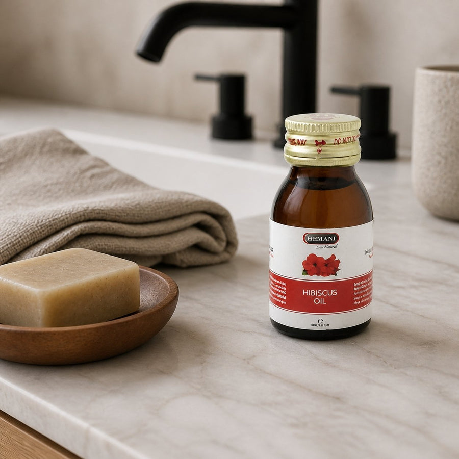 4 Huiles d'Hibiscus 30mL 100% Naturelle Hemani – présentation du produit dans une salle de bain lumineuse et naturelle