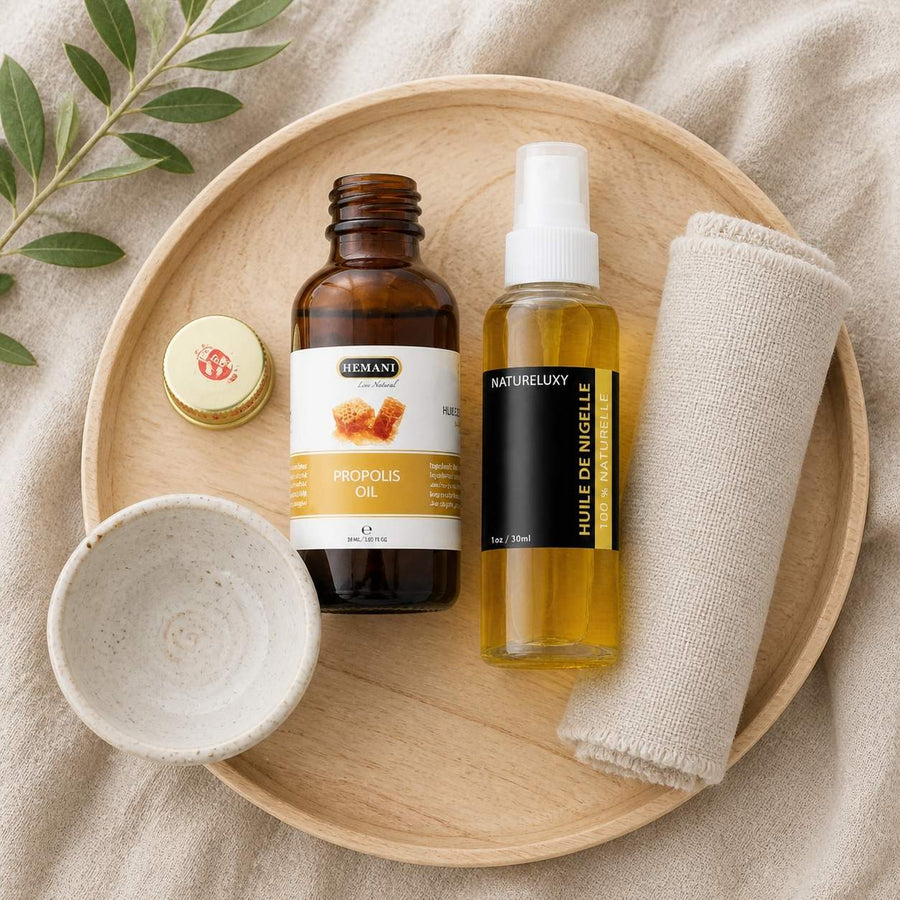 Pack Huile de Nigelle 30mL Spay + Huile de Propolis 30mL Hemani – rituel d'utilisation vu du dessus, ambiance naturelle zen