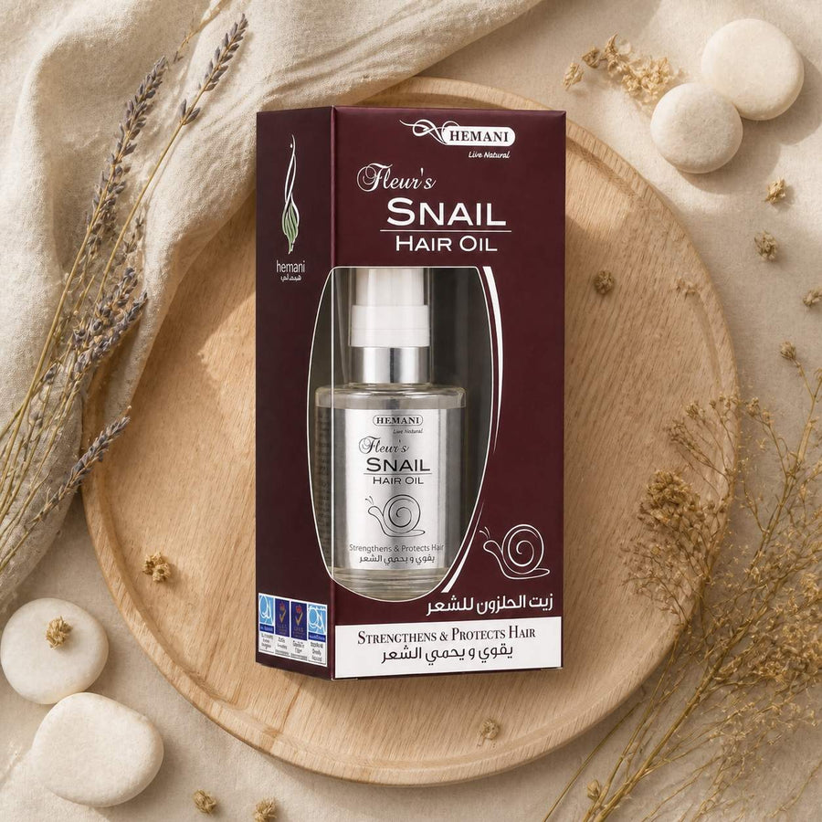 Huile capillaire à la bave d'escargot - Hemani 60mL – composition flat lay avec éléments naturels, vue du dessus